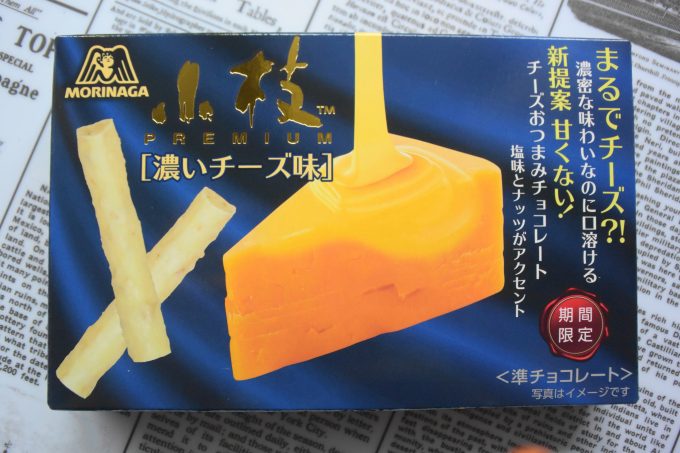 森永製菓 小枝プレミアム＜濃いチーズ味＞_濃いブルーの背景に浮かび上がる濃い黄色のチェダーチーズがとても印象的なパッケージです